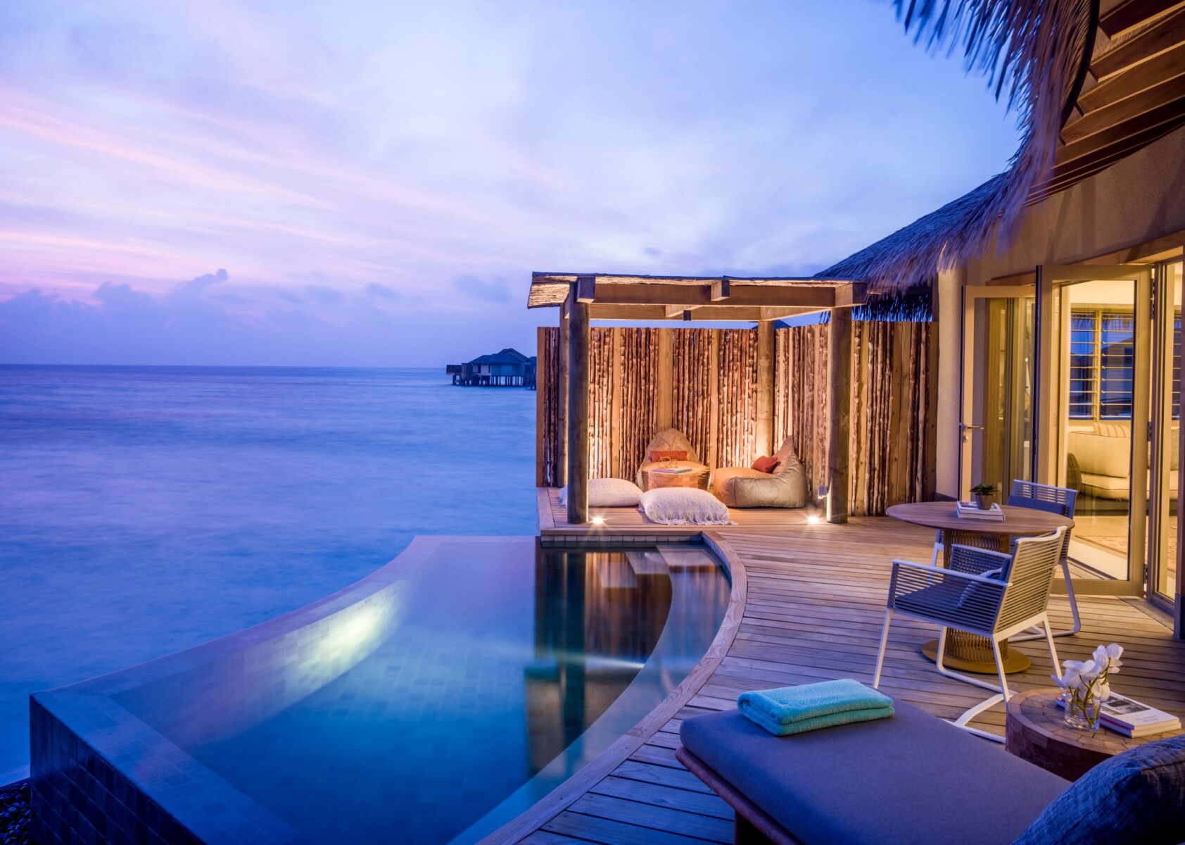 Luxuriöse Overwater Bungalows mit privatem Pool über türkisfarbenem Wasser in den Malediven